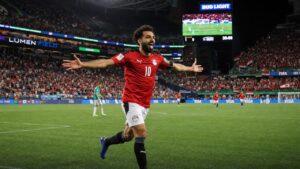 Egyptian soccer player in red national team jersey celebrating a goal at the World Cup in Seattle