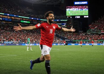 Egyptian soccer player in red national team jersey celebrating a goal at the World Cup in Seattle