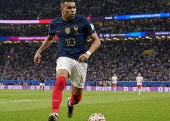 soccer player sprinting with the ball in a packed World Cup stadium
