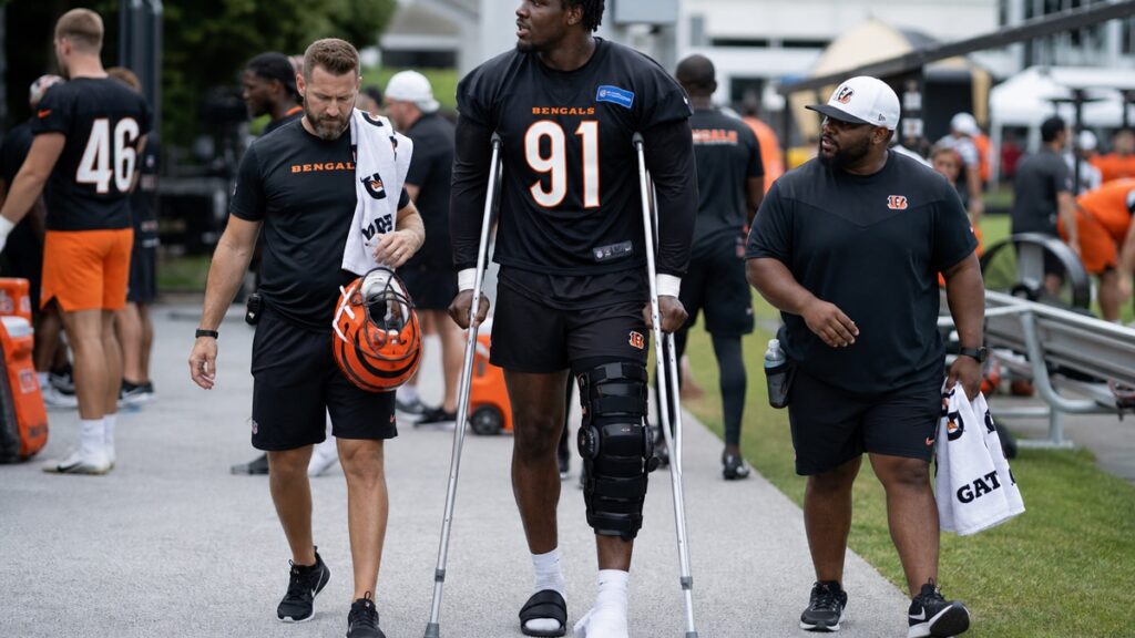 Shemar Stewart on the Bengals practice field sideline in a brace after his knee injury