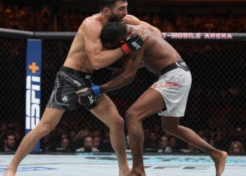 MMA fighters grappling in the octagon during a UFC prelim bout