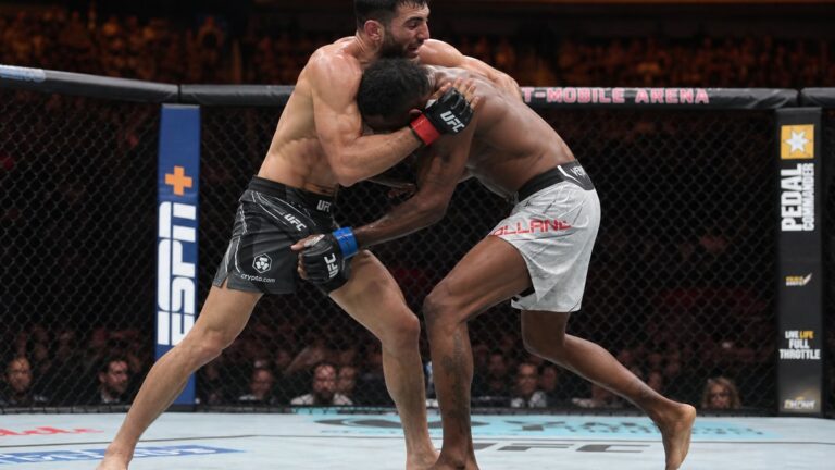 MMA fighters grappling in the octagon during a UFC prelim bout