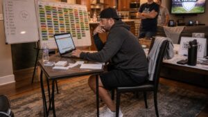 Fantasy football manager reviewing auction draft budget tiers and player values before a live draft