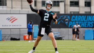 Kyle Trask throwing a pass in a Carolina Panthers uniform during practice