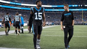 Carolina Panthers receiver in a walking boot on the sideline during a preseason game