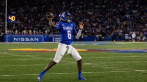 Kansas Jayhawks quarterback throwing a pass during the Border War rivalry game against Missouri