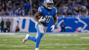 Isiah Pacheco running with the ball in a Detroit Lions uniform