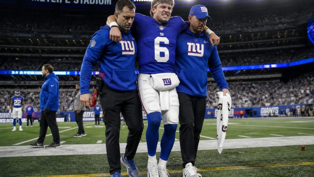 Jaxson Dart of the New York Giants on the sideline after suffering a knee injury