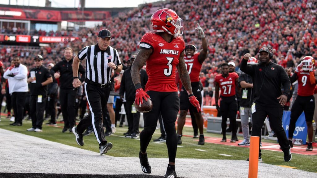 Louisville Cardinals football player in action on the sideline during a game