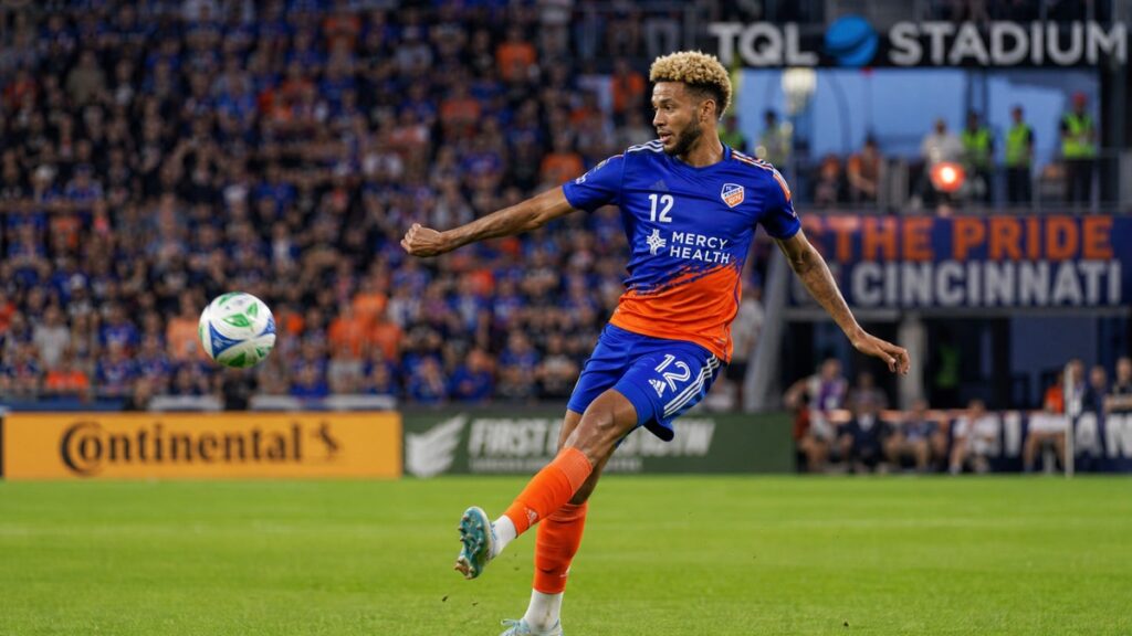 Miles Robinson clearing the ball for FC Cincinnati in his orange and blue kit