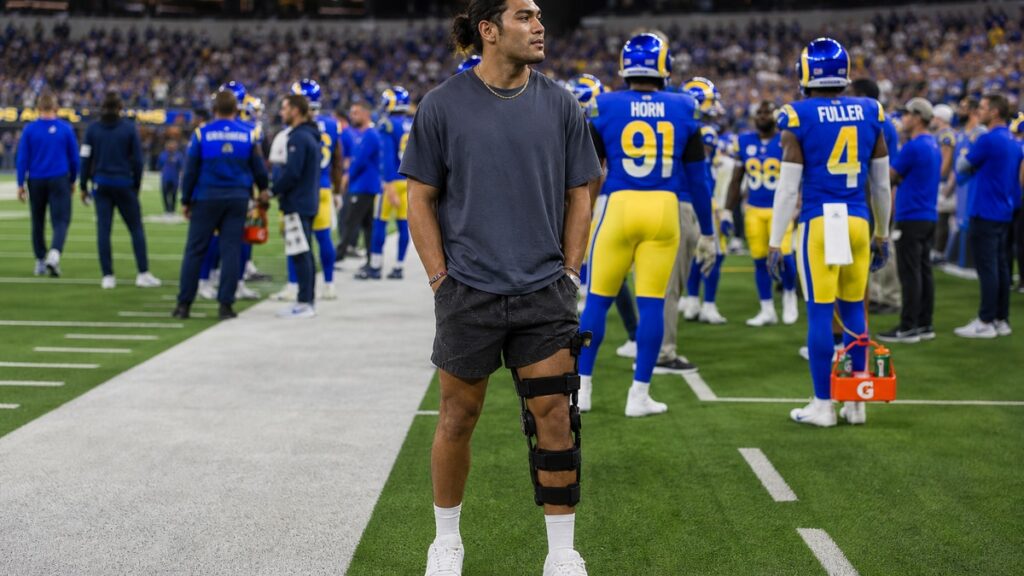 Puka Nacua on the Los Angeles Rams sideline in Rams jersey number 17 while dealing with a hip injury