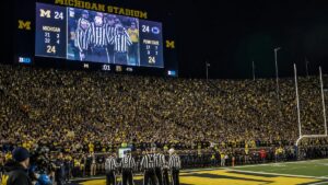 Michigan football stadium scoreboard and officials reviewing the final-play Hail Mary clock ruling against Western Michigan