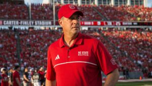 Head coach standing on the NC State Wolfpack sideline at Carter-Finley Stadium in Raleigh