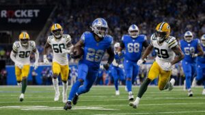 Jahmyr Gibbs of the Detroit Lions running with the football against the Green Bay Packers at Ford Field