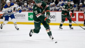 Matt Boldy of the Minnesota Wild skating with the puck and shooting on goal